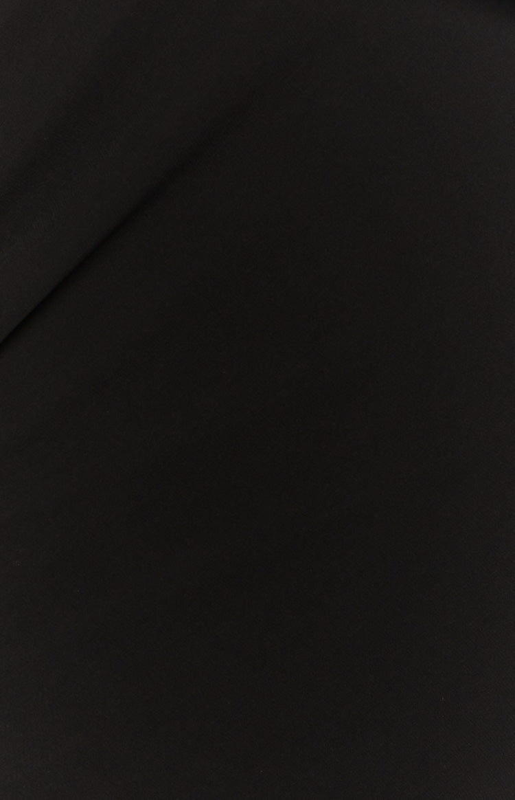 Close-up of the smooth black fabric of the maxi skirt with a subtle diagonal fold