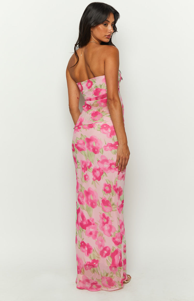 Side view of a pink floral print maxi skirt with bright pink and green flowers, highlighting the fitted waist and flowing hem