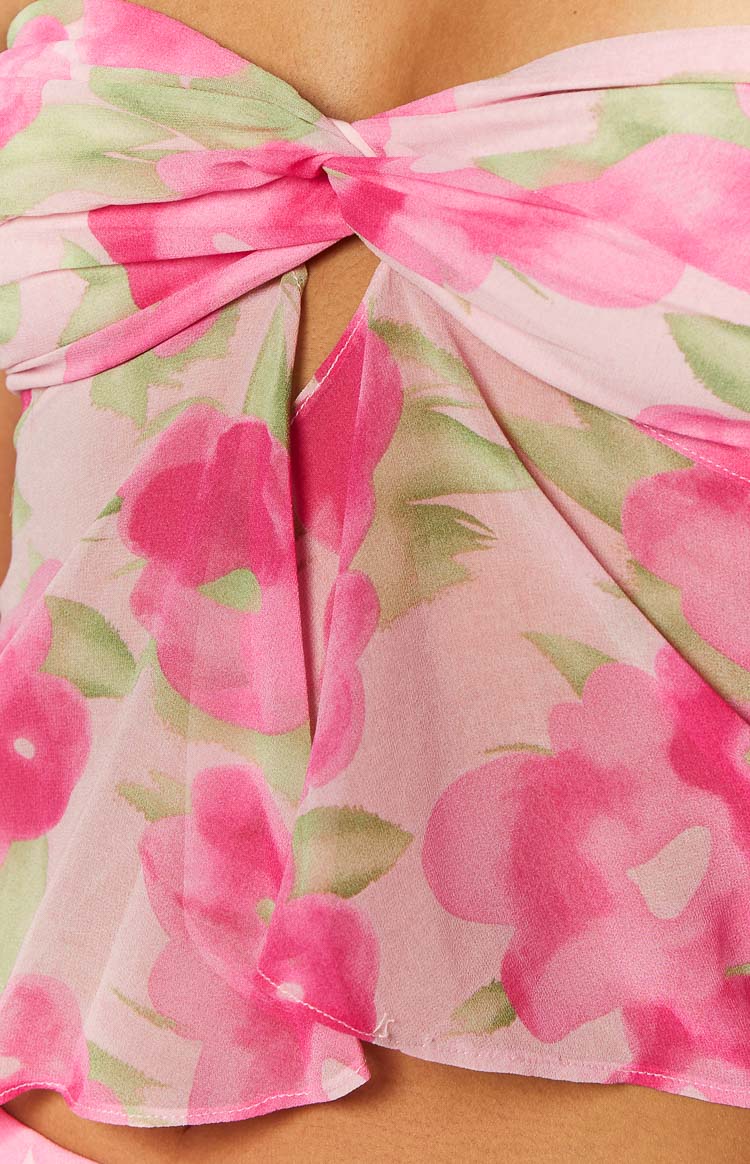 Close-up of the twisted bust detail and keyhole cut-out on a pink floral print strapless top