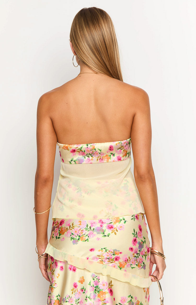Back view of the yellow floral strapless top with a wide band of concentrated pink and purple bloom print
