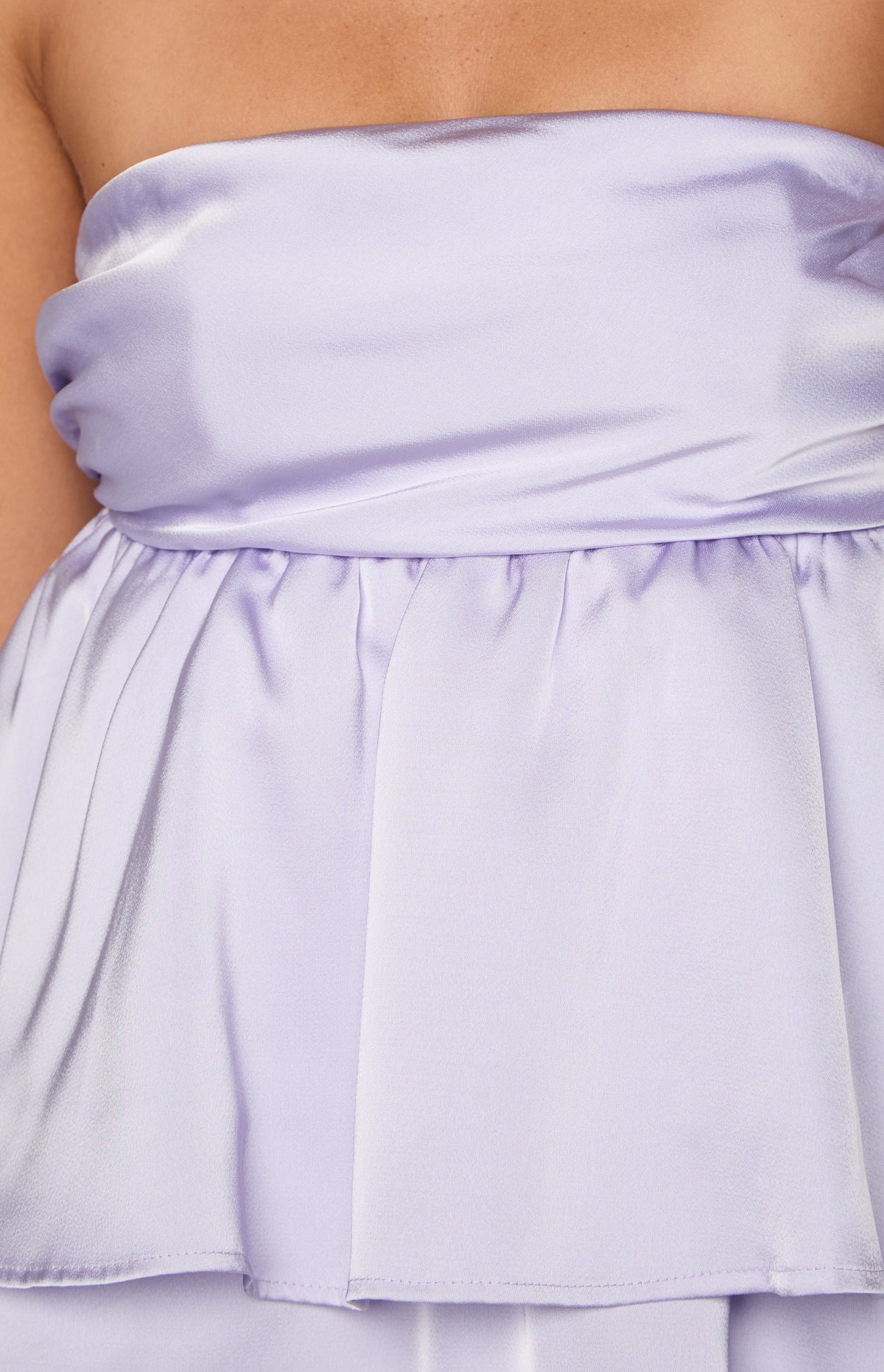 Close-up of the lilac satin mini dress showing the gathered waist and the first tier of the skirt