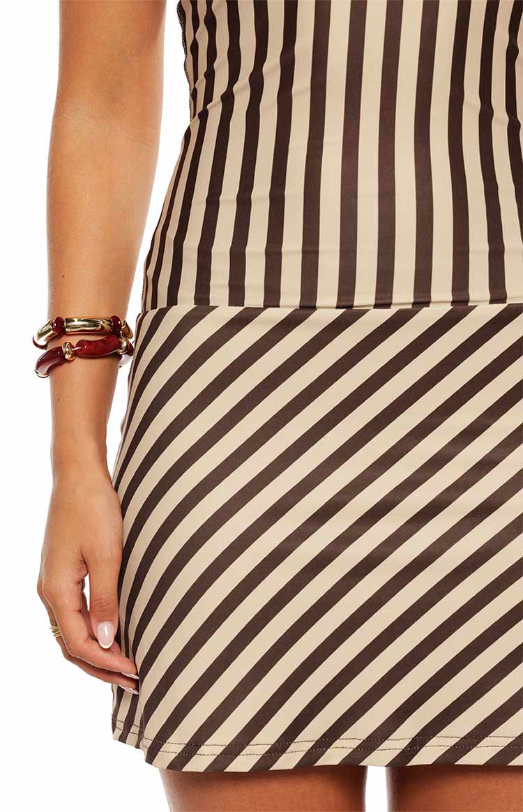 Close-up of the brown and beige stripe mini dress showing the transition from vertical to diagonal stripes