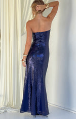 Rear view of a navy sequin strapless maxi dress with a fitted back and a flared hem with plain panels