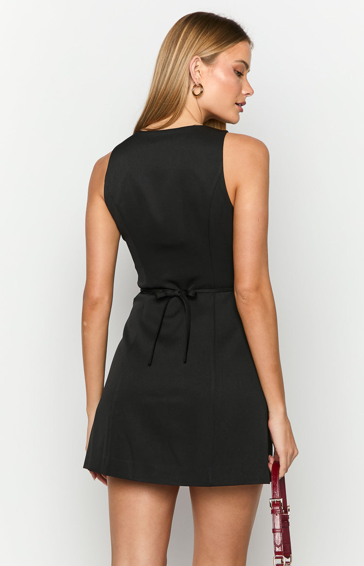 Rear view of a black mini dress showing the tie-back waist detail and sleeveless design