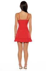 Rear view of a red polka dot mini dress with thin spaghetti straps, a square back, and ruffled hem