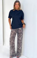 Full length front view of black sheer zebra print wide leg pants with a visible drawstring waist