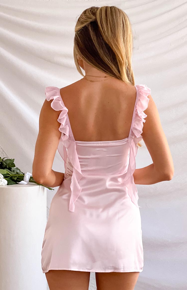 Rear view of a pink satin mini dress with a square back, ruffled shoulder straps, and sheer fabric ties
