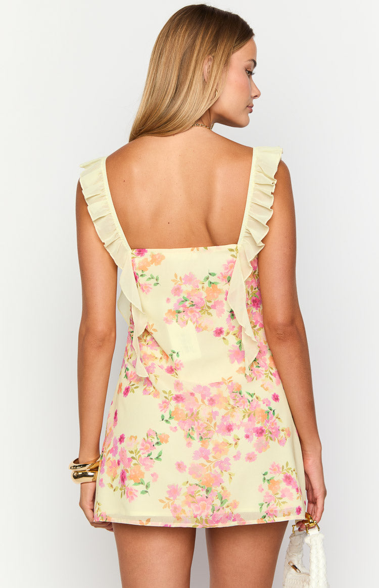 Rear view of a yellow floral chiffon mini dress with a square back and ruffled straps