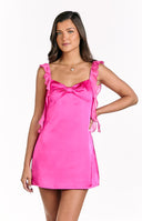 A vibrant hot pink mini dress with a sweetheart neckline featuring a large bow detail- and ruffled shoulder straps- suitable for a lively party or homecoming.