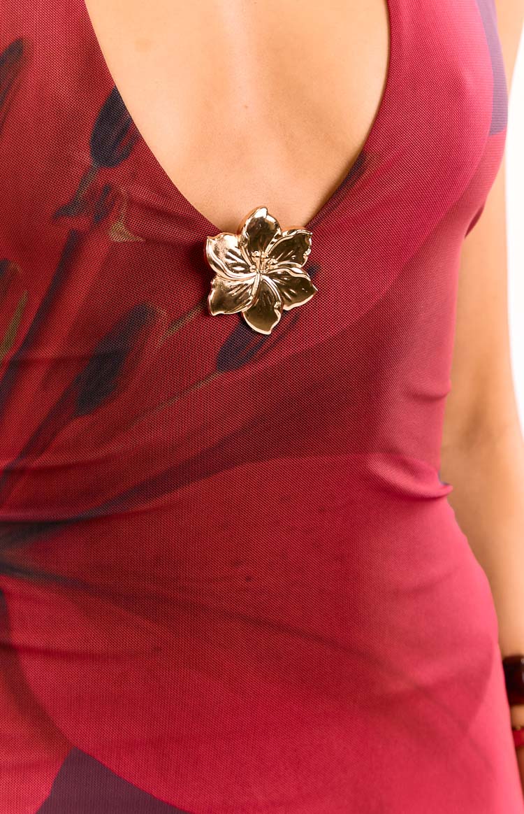 Close-up of the gold flower embellishment at the V-neck of the purple floral mesh mini dress
