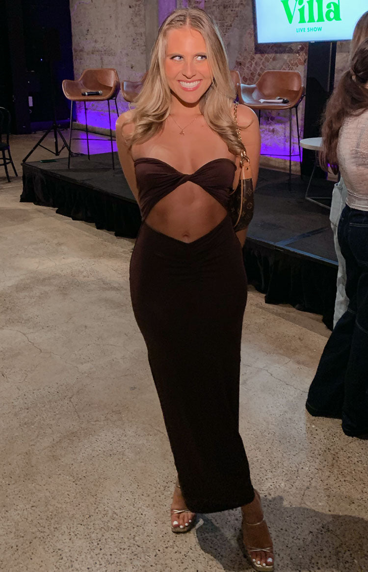 Front view of a brown strapless midi dress with twisted bandeau top, midriff cutouts, and ruched waist