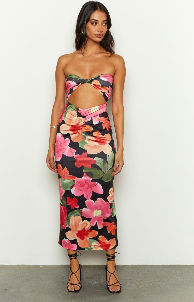 Front view of a black floral midi dress with a strapless twisted bust and midriff cutout