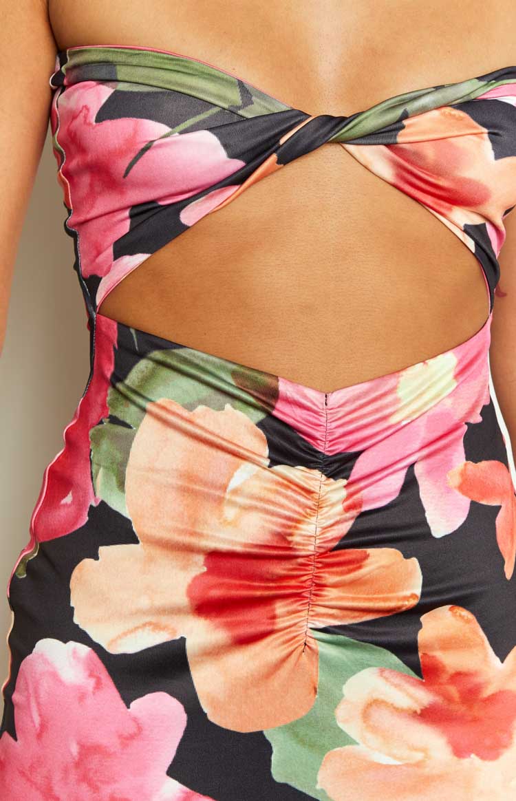 Close-up of the twisted bodice and front cutout with ruched detail on a black floral midi dress