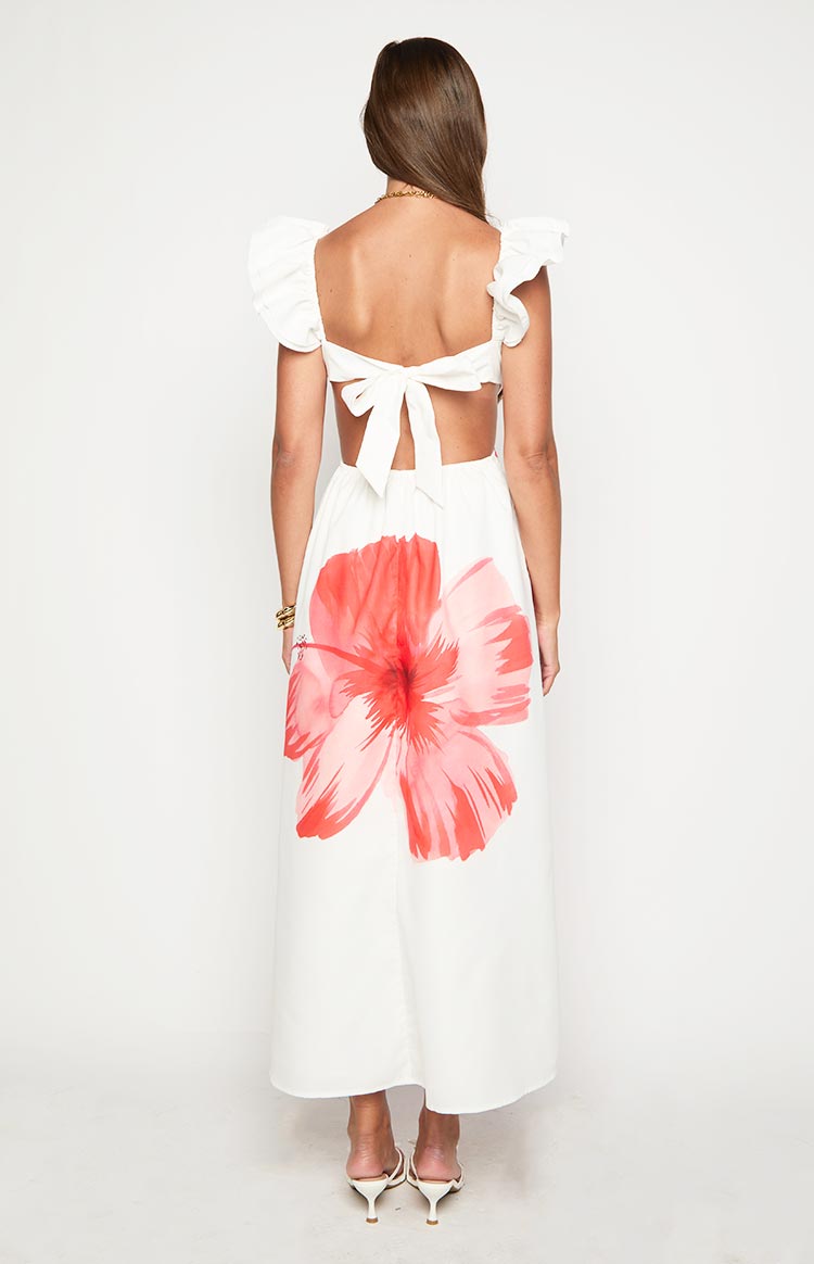Rear view of a white maxi dress with a large red floral print, tie-back, waist cutouts, and ruffled cap sleeves