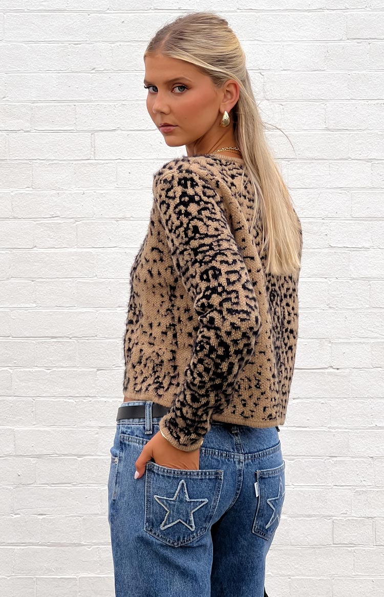 Side view of a cropped tan and black leopard print cardigan with long sleeves and a fuzzy knit texture