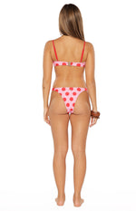 Rear view of a pink and red polka dot bikini top with red spaghetti straps and a gold clasp, paired with matching high-cut bottoms