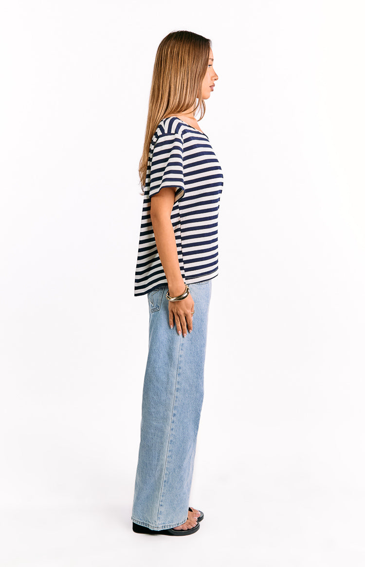 Side view of a navy and white striped oversized top with short sleeves and a relaxed fit