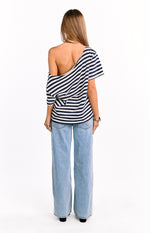 Rear view of a navy and white striped oversized top with a wide off-shoulder neckline and loose drape
