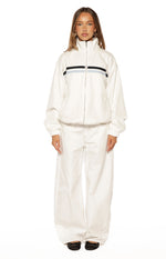 Full front view of a cream funnel neck jacket with black and light blue chest stripes, elasticated cuffs and hem