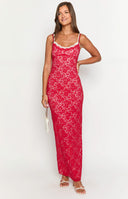 a girl with blonde hair wears a red and white lace maxi dress with gold bracelets and white heels holding a red rose