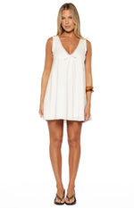 White cotton mini dress with subtle vertical stripes, lace trim V-neck, and tie-front bow
