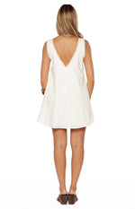 Rear view of a white cotton mini dress with a deep V-backline and delicate lace trim on the neckline and armholes