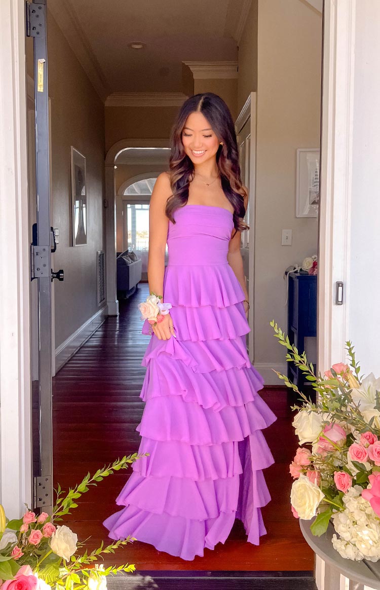 Full length view of a magenta strapless maxi dress with a fitted bodice and cascading tiered ruffles