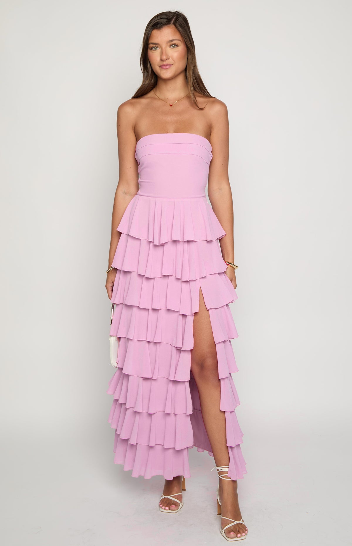 Pink strapless maxi dress with a fitted bodice, tiered ruffles, and a high leg slit