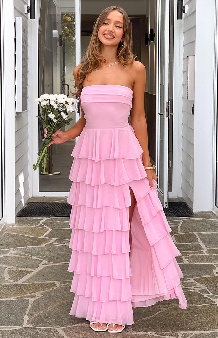 A long- light pink strapless gown featuring multiple tiers of ruffles from the waist down- with a high slit on the left side- suitable for a formal event or special occasion.
