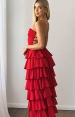 Side view of a red strapless maxi dress with side cutouts, lace-up bodice, and tiered ruffle skirt