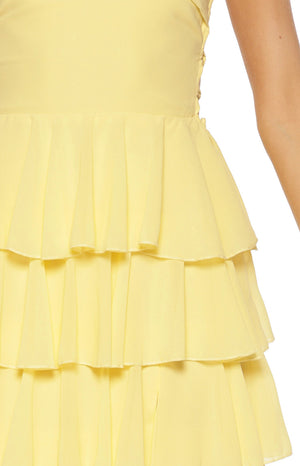 Close-up of the yellow tiered ruffle skirt of the maxi dress with side lace-up detail