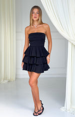 Black strapless mini dress with a fitted bodice featuring horizontal pleats and a three-tiered ruffle skirt