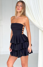 Black strapless mini dress with side lace-up cutouts and a tiered ruffle skirt