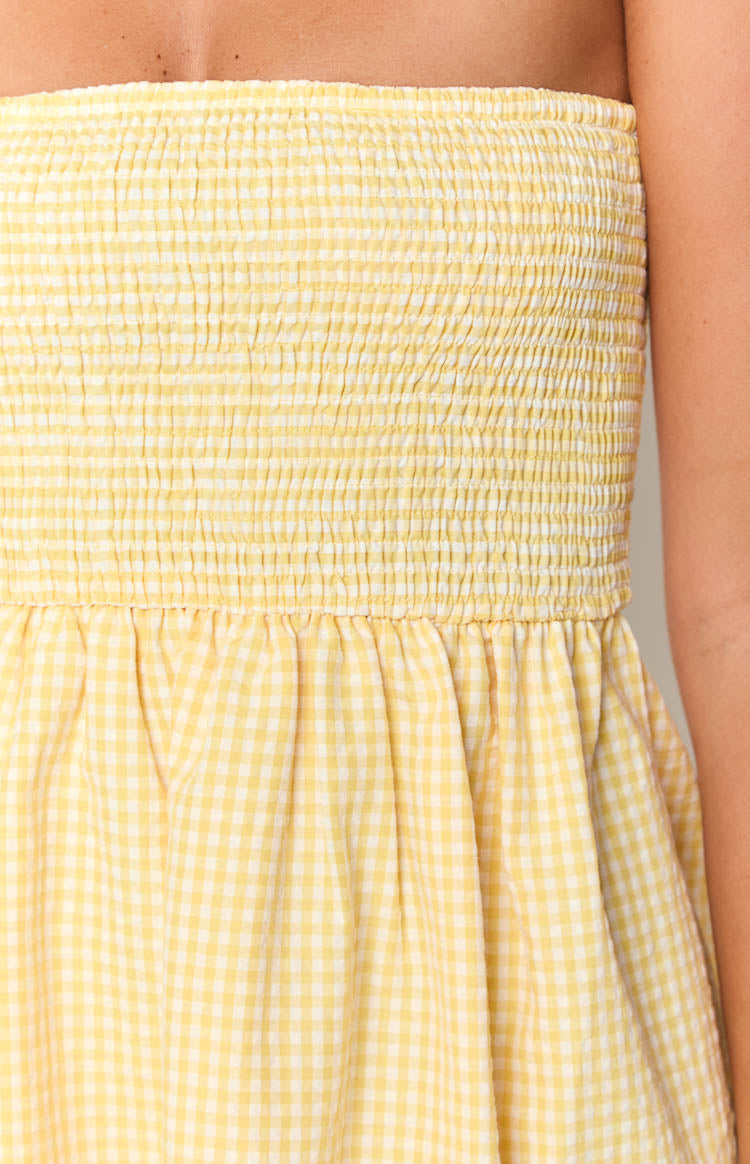 Close-up of the yellow gingham shirred bodice and gathered skirt of the mini dress