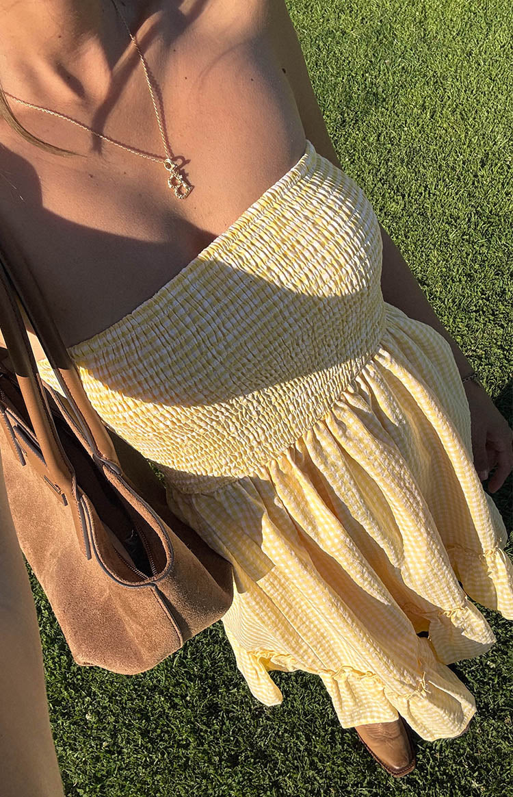 Top-down view of a yellow gingham mini dress with a smocked strapless bodice and a flowy skirt