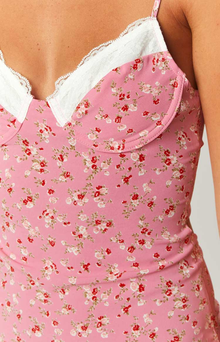 Close-up of the pink floral midi dress showing the white lace trim, bust cups, and red and white floral print