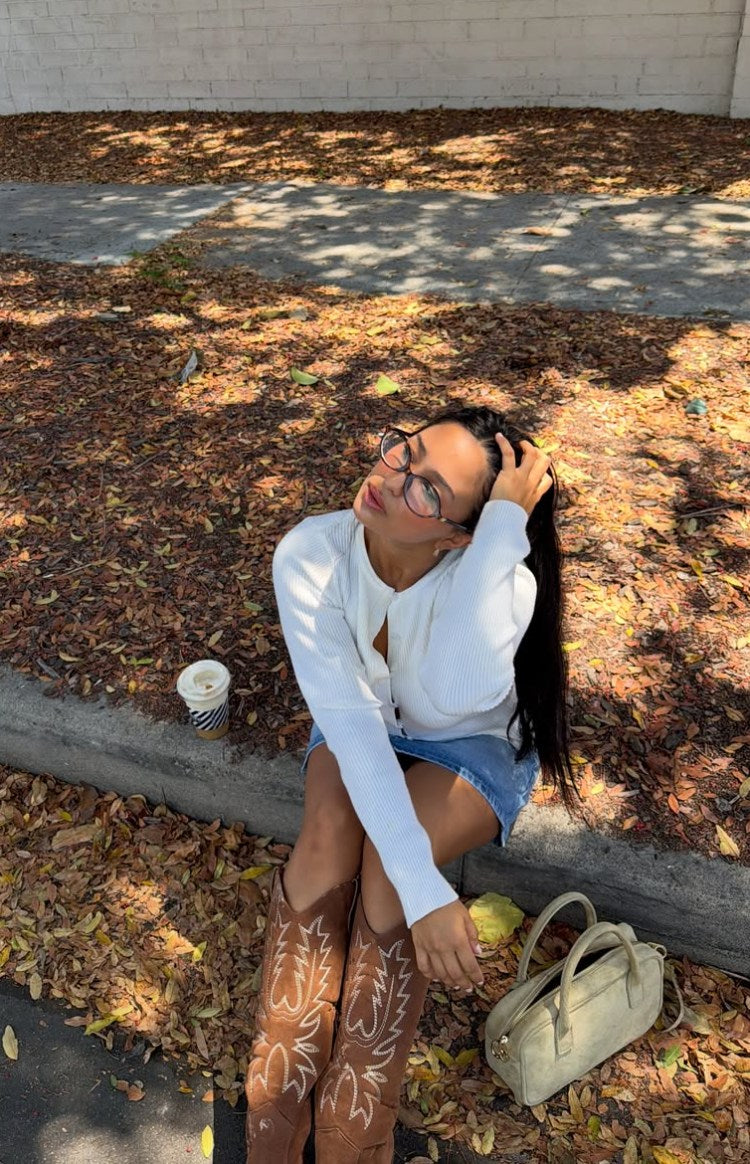 White ribbed knit long sleeve sweater with an unbuttoned front and V-neckline