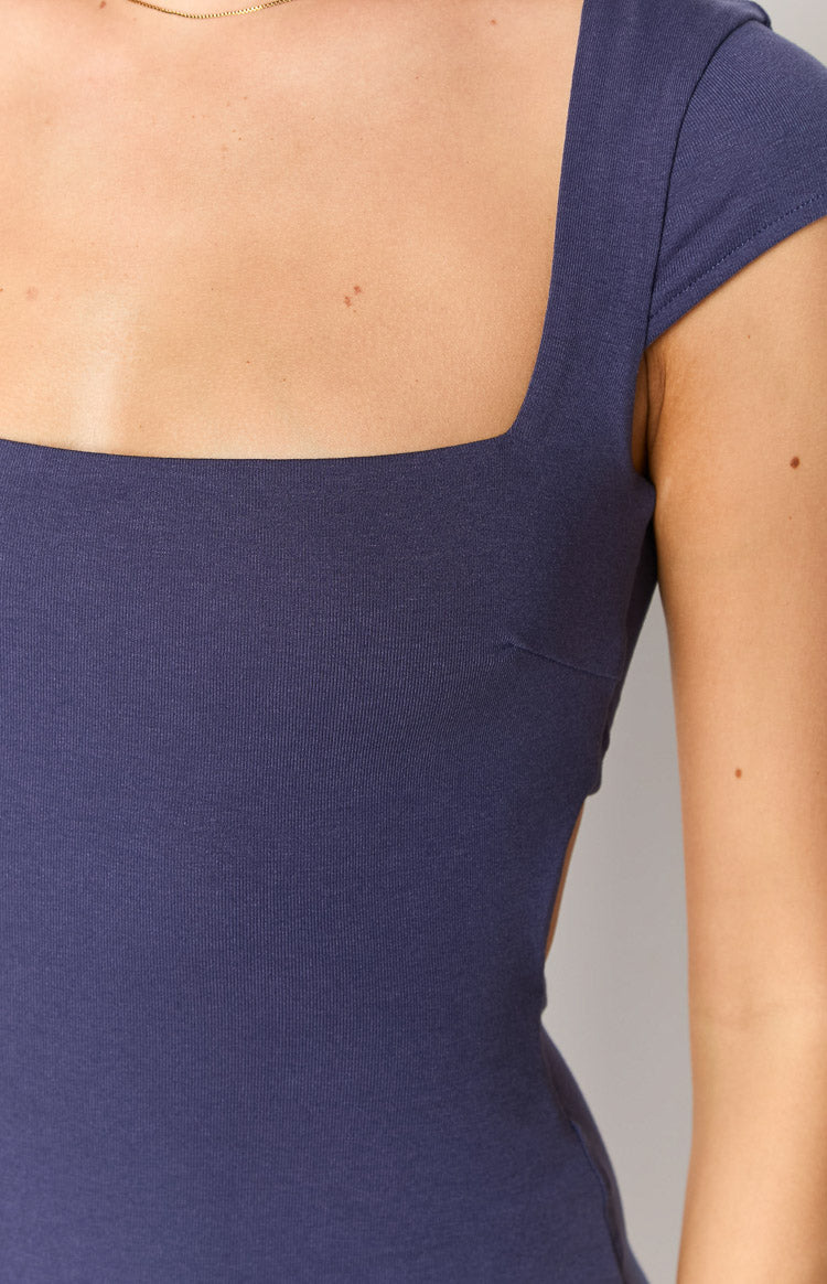 Detail shot of the navy ribbed knit mini dress showing the square neckline, cap sleeves, and side cutout