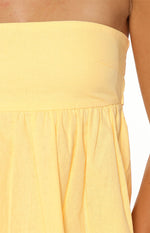 Close-up of the yellow textured strapless top showing the smooth bodice and gathered elasticated waist