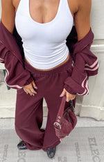 Burgundy wide-leg track pants with an elasticated waistband and relaxed fit