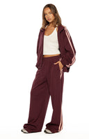 Beginning Boutique Kosie Burgundy and Pink Stripe Track Pants — burgundy wide-leg track pants with pink side stripes and elasticated waist