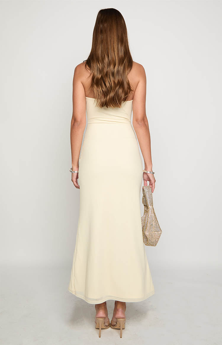 Rear view of a cream strapless maxi dress with a subtle mesh hem