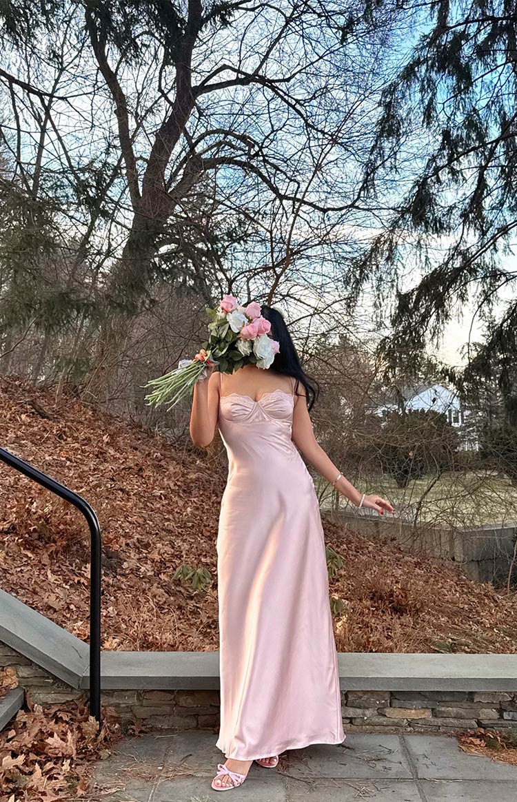 Full length view of a light pink satin maxi dress with a sweetheart neckline, lace trim, and bust detailing