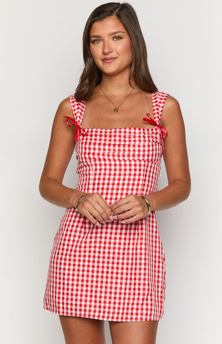 Front view of a red and white gingham mini dress with a square neckline and red bow-tied shoulder straps