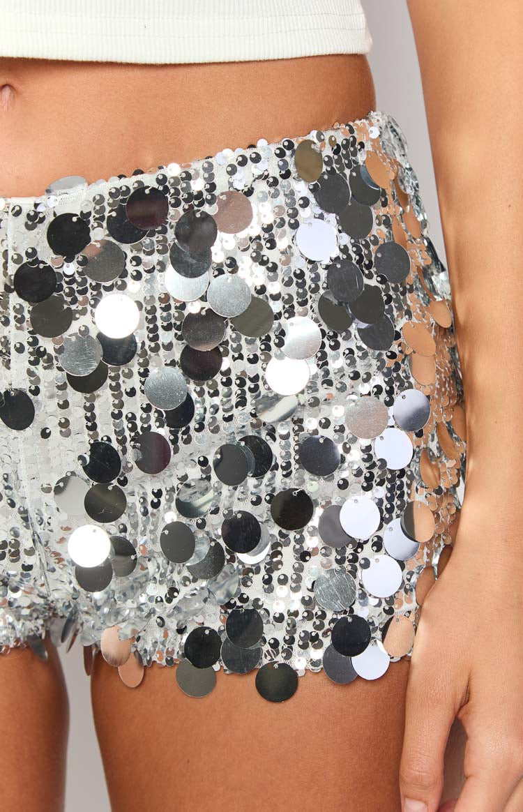 Close-up of the silver micro shorts showing the layered disc sequins and tiny silver beads