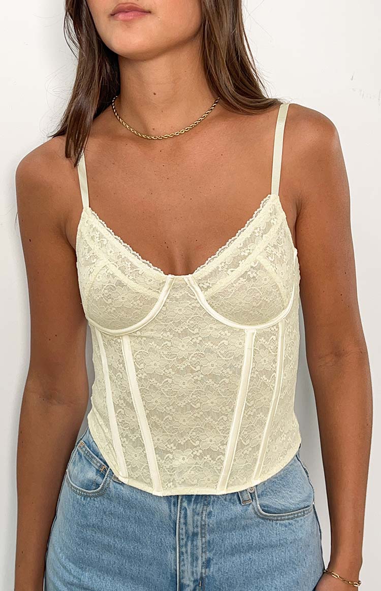 Close-up of the cream lace corset top showing the sweetheart neckline, delicate lace trim, and structured boning