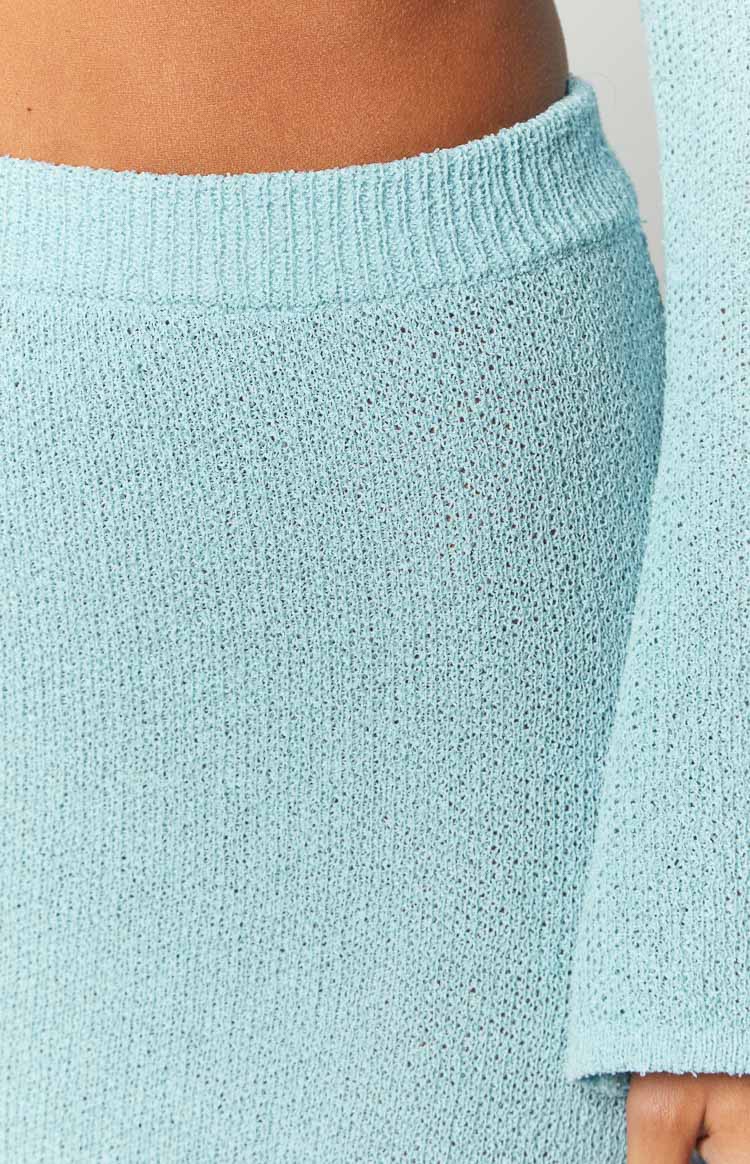 Close-up of the ribbed knit waistband and the open-knit texture of the blue maxi skirt