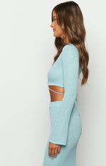 Light blue knit long sleeve top side view with a midriff cutout and thin tie-back straps