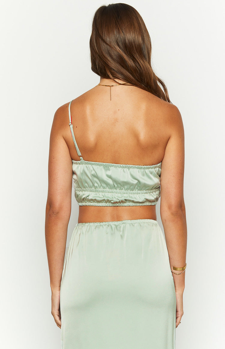 Rear view of a sage satin crop top with a single adjustable spaghetti strap and ruched back