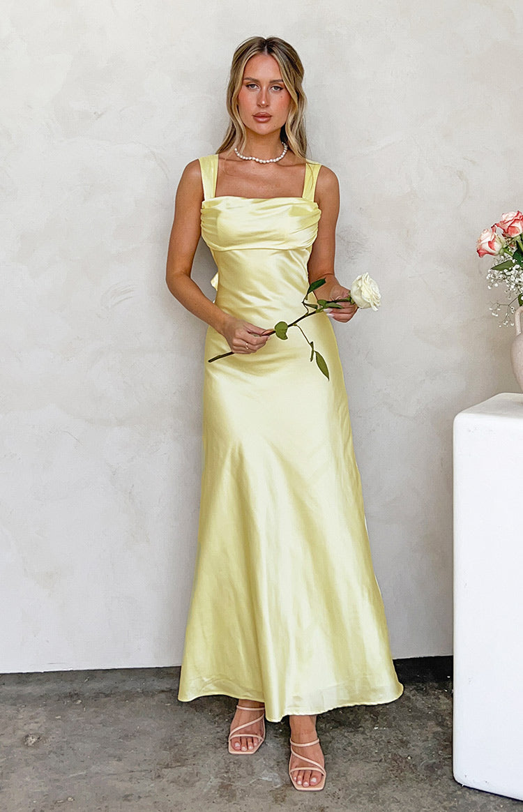Full length front view of a yellow satin maxi dress with a square neckline and ruched bust detail